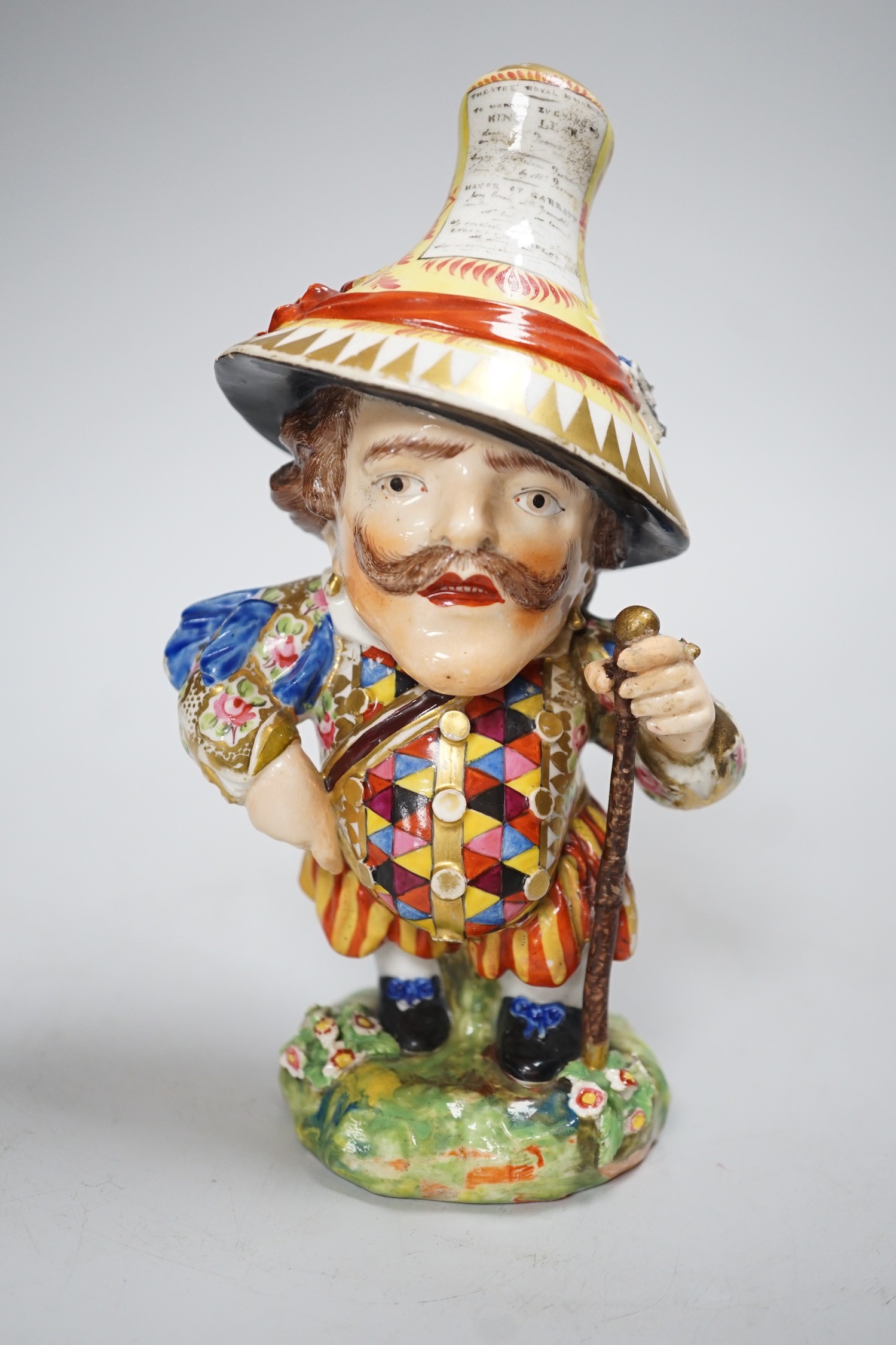 A Derby Mansion House Dwarf holding a walking stick, his hat with advertising, incised 227, c.1790-1800